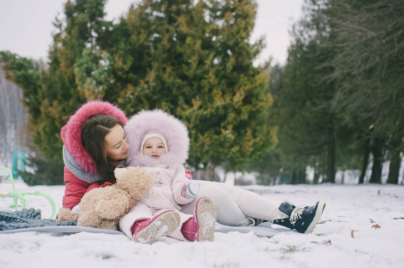 Mom and baby daughter enjoying snow